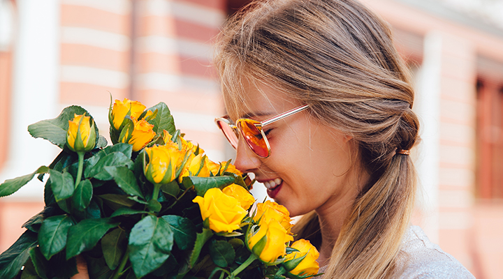 Una mujer huele unas flores