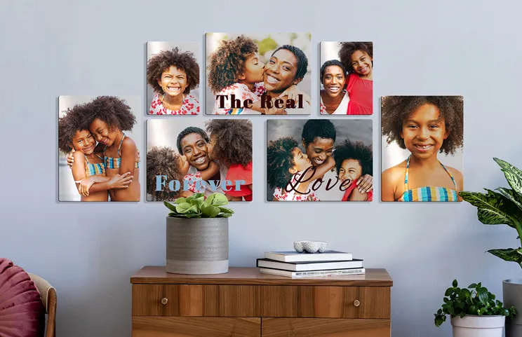 Impresión de foto en metal por Printerpix|Impresión de foto en aluminio de una montaña y un lago sostenida por una mujer hecha por Printerpix|Pequeña impresión metálica cuadrada de un hombre zambulléndose en un lago|Impresión de foto en metal de madre e hija en la estantería|Mujer colocando impresión metálica de novia y novio en la pared|Tres impresiones de fotos en metal de tamaños variados|||||