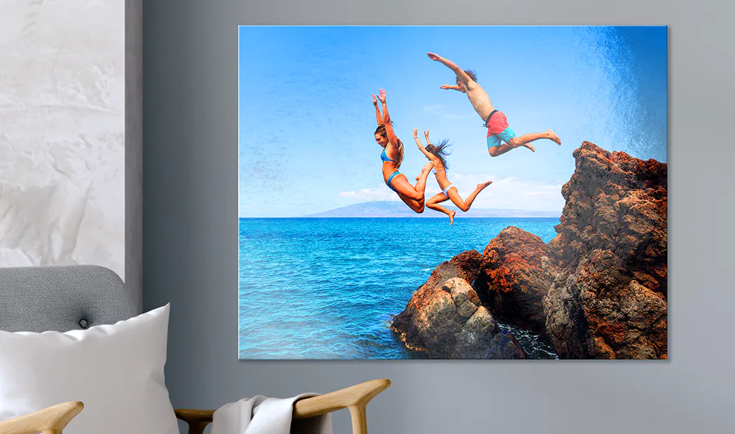 Impresión de foto en metal personalizada: Tres amigos saltan de rocas a un océano turquesa vibrante. Una pieza impresionante y a medida para tu hogar.