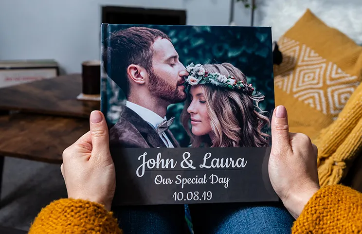Libros de fotos personalizados con tapa dura de Printerpix|Álbum de fotos personalizado de Printerpix con tapa dura y fotos grandes de una pareja mayor|Álbum de fotos personalizado con imágenes románticas de una pareja y portada de fotos|Álbum de fotos familiar con portada impresa personalizada y texto del nombre de la familia|Mascota y mujer mirando un libro de fotos familiar personalizado con diseño personalizado|Dos personas mirando un libro de fotos personalizado de Printerpix con fotos de boda y novia|||||