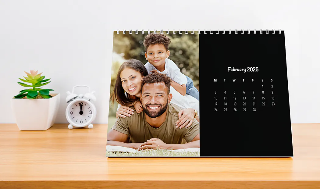 Mujer escribiendo en calendario de pared personalizado A4 de printerpix con foto de tema navideño