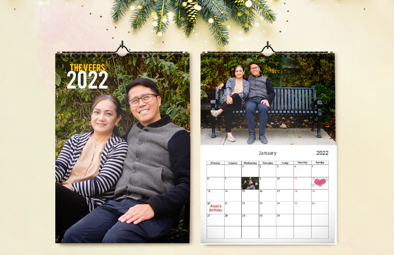 Mujer escribiendo en calendario de pared personalizado A4 de printerpix con foto de tema navideño