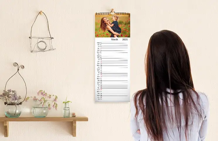 Calendario de cocina colgado en la pared de la cocina con fotos de vacaciones familiares