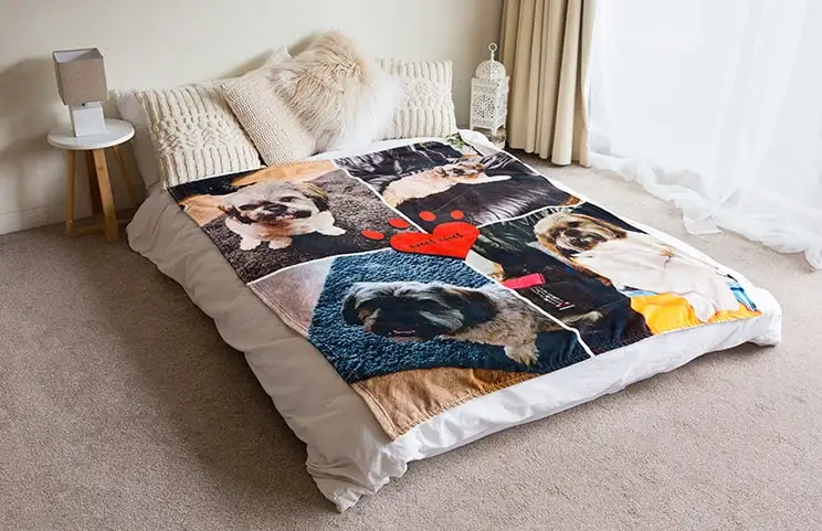 Una manta suave de toque de visón de Printerpix con diseño de collage de perros está extendida sobre una cama.