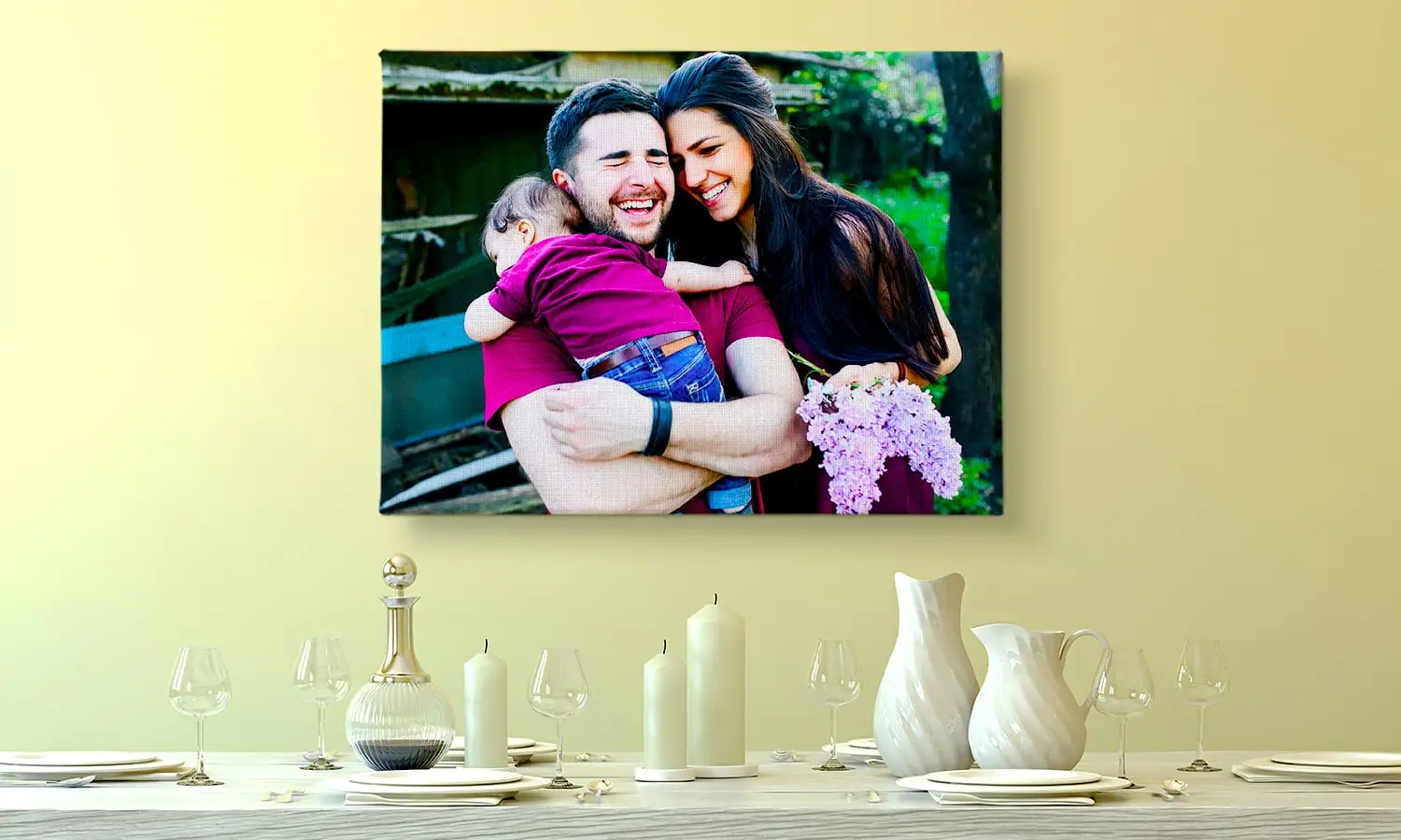 Joven sosteniendo un lienzo de dos personas sentadas junto a un lago contra una pared, dirigido por una joven