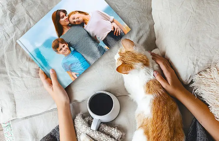Mascota y mujer mirando álbum de fotos familiar personalizado con diseño exclusivo