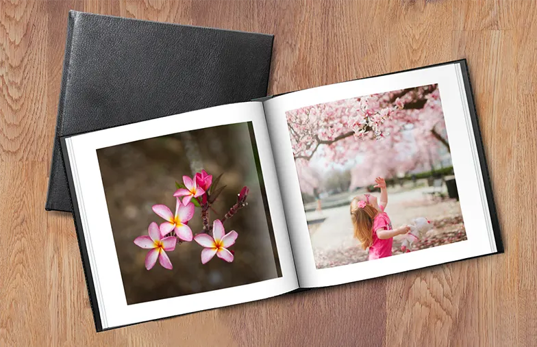 Pareja mira libro de fotos personalizado con cubierta de cuero hecho por Printerpix