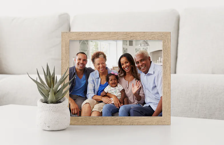 Foto familiar personalizada: tres generaciones sonriendo juntas en un hogar luminoso y aireado. ¡Atesora tus recuerdos!