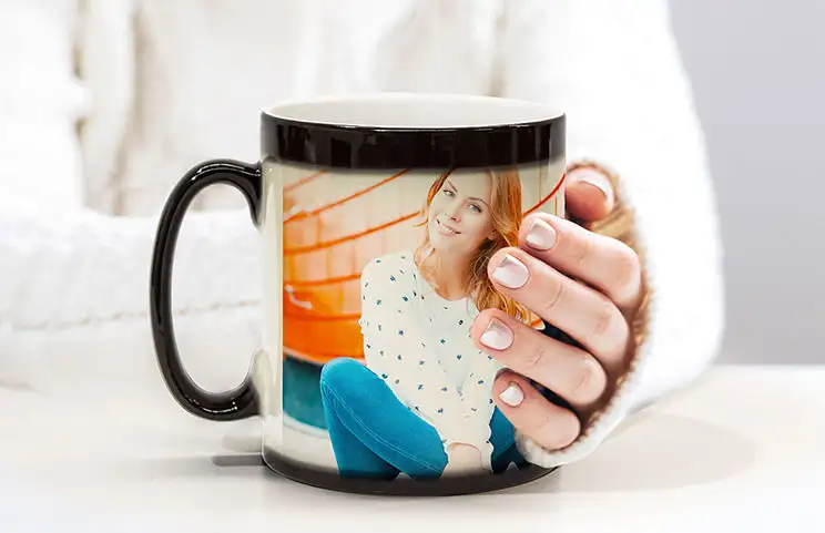 Pareja sosteniendo dos tazas mágicas que cambian con el calor con texto personalizado de Printerpix