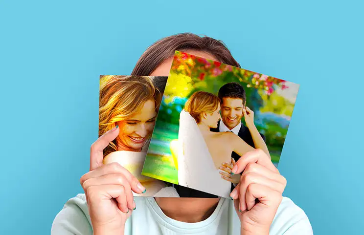 Mujer sosteniendo dos impresiones de fotos de boda en metal